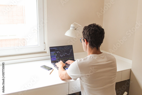 businessman working from home, watching on his laptop the stocks of his company