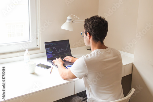 businessman working from home, watching on his laptop the stocks of his company
