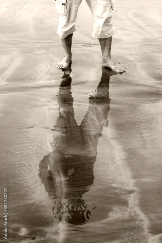 Personenspiegelung im nassen Strandsand