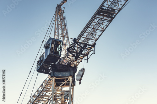 Stationary construction tower crane detail. The cab, jib and trolley are visible. Space for copy to the right.