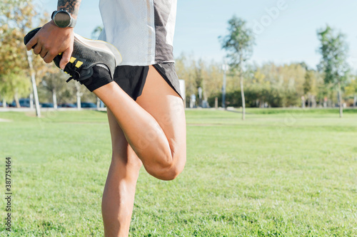 Runner stretching in city park