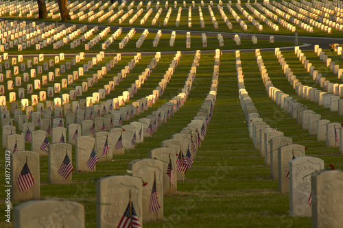 Rows of U.S. service members graves with American flags at sunset in the National Cemetery in Los Angeles