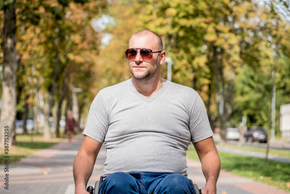 Handicapped man in wheelchair walk at the park alley Handicapped man in wheelchair walk at the park alley