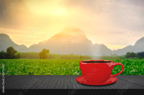 Hot coffee red cup hot drink on a wood table, The background is a landscape of nature with mountains and green farms With morning light. Coffee break concept.