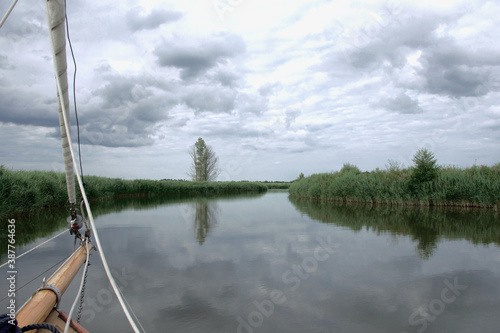 Canvas Print Bowsprit of a sailing yacht on a tranquil river