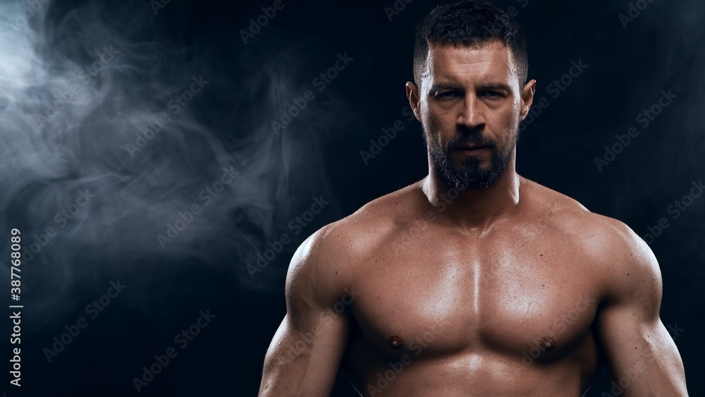 Fit and sporty bodybuilder over black background. Sportsman in studio. Sport and fitness concepts. Fit and sporty bodybuilder over black background. Sportsman in studio. Sport and fitness concepts.