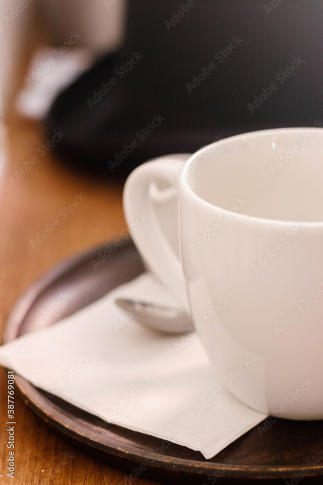 Closeup of a white cup with spoon on a white napkin 