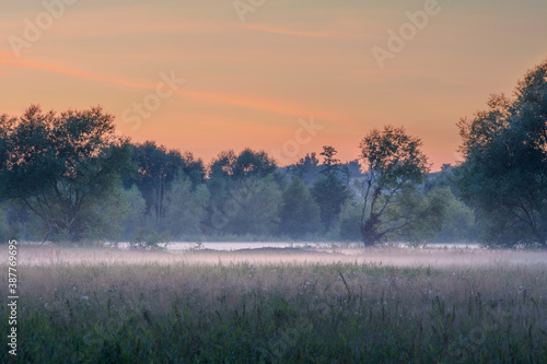 misty sunrise over fields and meadows