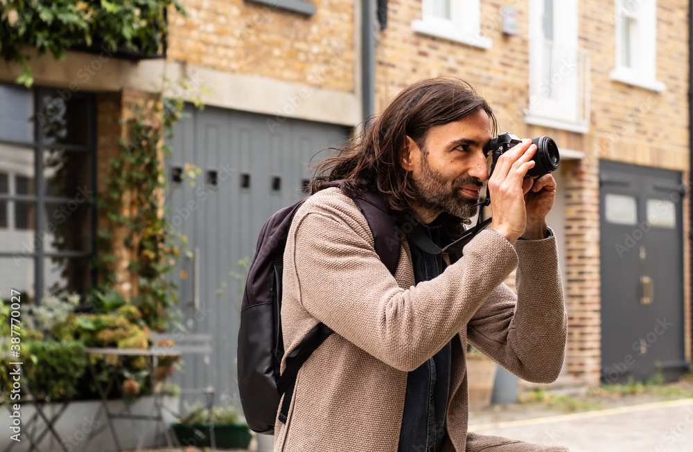 Portrait of a male photographer who is taking photos in a small alley in London, United Kingdom