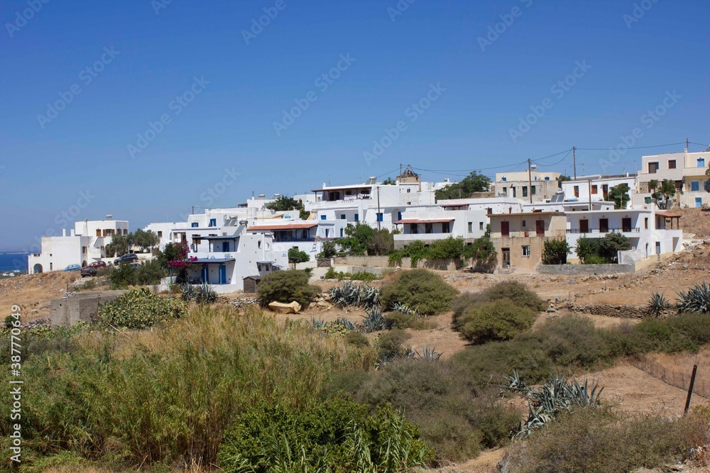 row of houses in Naxos Island through fields