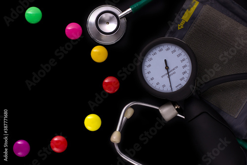 medical tonometer, background frame made of colored magnetic paper clips on black background with space for text