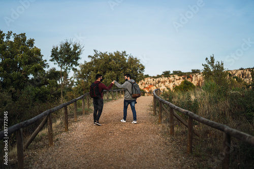 Dos chicos jovenes chocando puño en la sierra de sevilla © MiguelAngelJunquera
