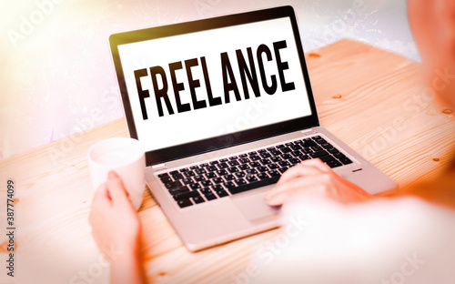 Conceptual hand writing showing Freelance. Concept meaning an individual who pursues a profession without a longterm commitment Modern gadgets white screen under colorful bokeh background