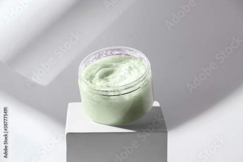 Green body scrub on a pedestal. White background