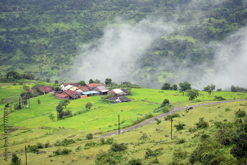 A landscape of small village in the sahyadri mountains. Few homes surrounded by green grass, trees, valleys, roads is a perfect wallpaper for printing, desktop and for backgrounds. photo
