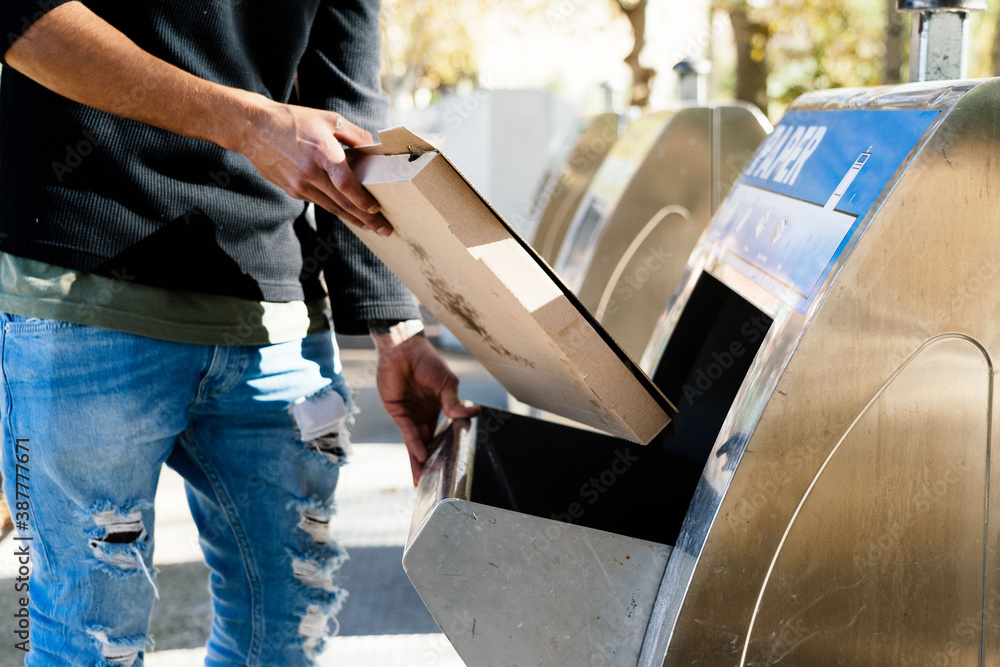 boy throwing cardboard in the recycle bin boy throwing cardboard in the recycle bin