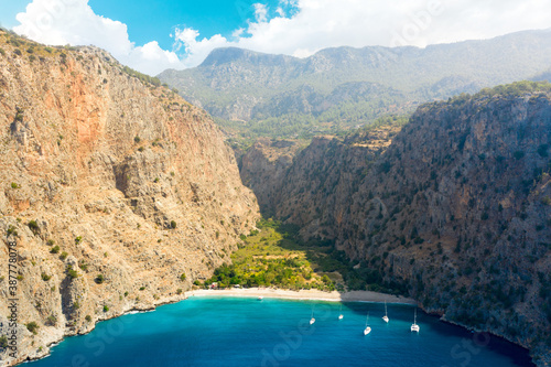 Aerial view over the clear beach and turquoise water of Butterfly Valley. In Turkish: Kelebekler Vadisi. Mugla Province, Turkey photo