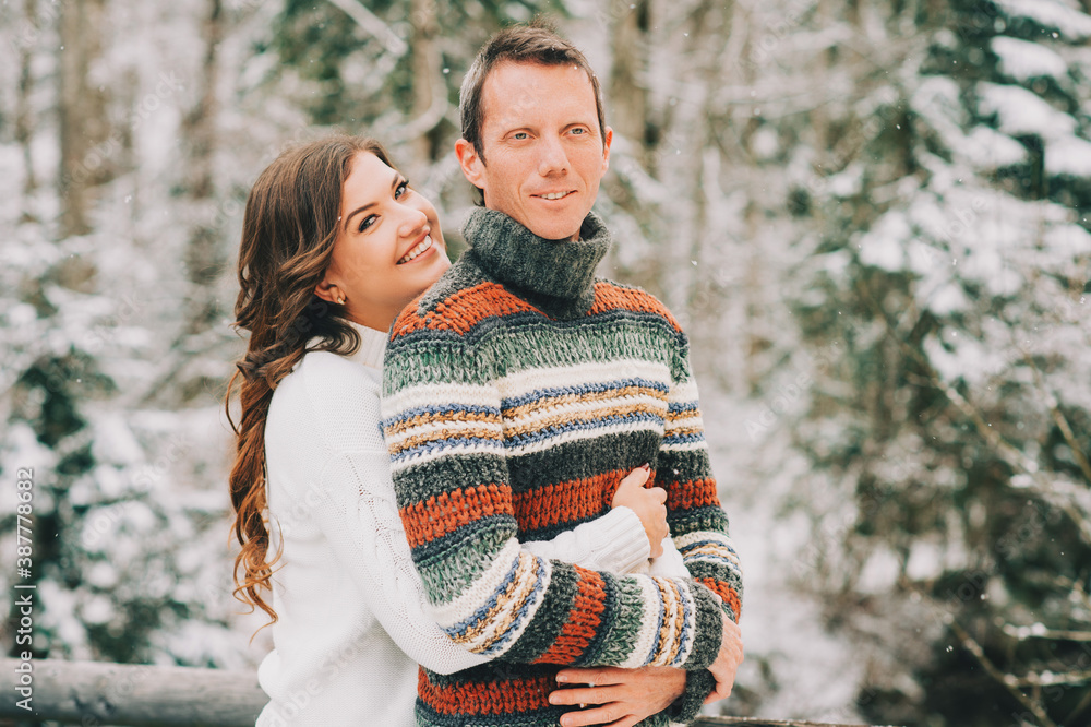 Fototapeta premium Outdoor portrait of happy middle age couple in winter forest