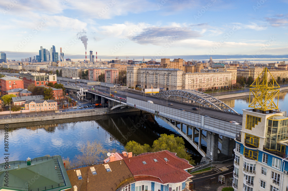Obraz premium cityscape at sunrise on autumn morning with old houses, highways and river shot from drone