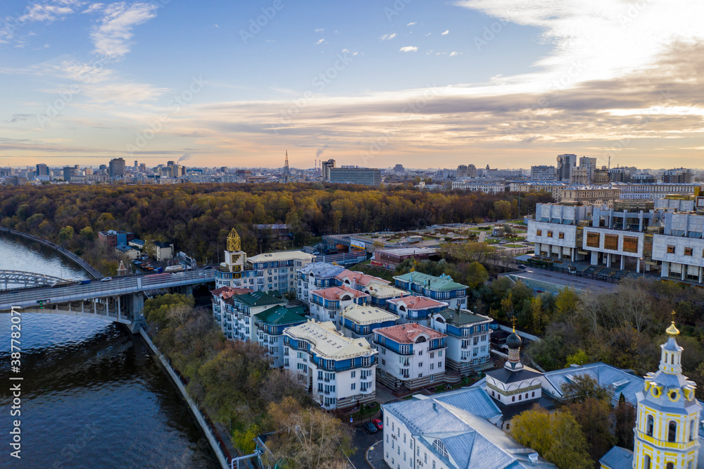 cityscape at sunrise on autumn morning with old houses, highways and river shot from drone