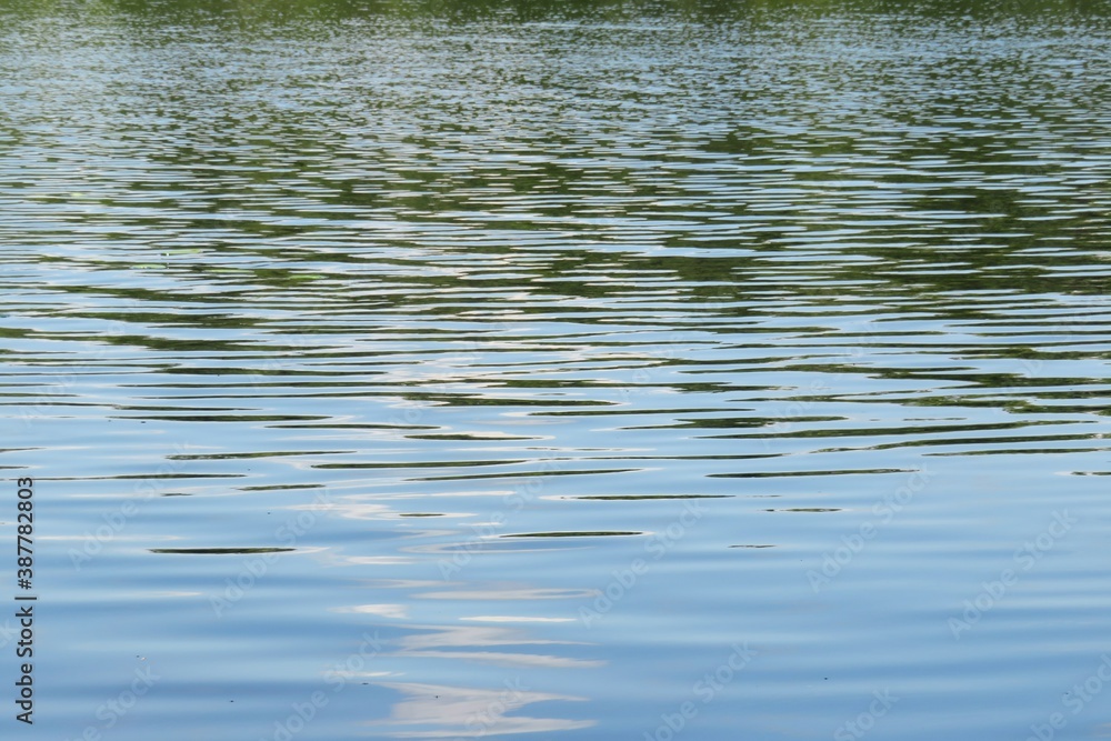 Ripples on light blue river water surface, natural blue water background Ripples on light blue river water surface, natural blue water background