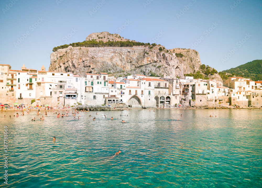 Characteristic view of the coastal city of Cefalù near Palermo in Sicily. It has a cristal clear blue water and nice old houses in front of the sea 