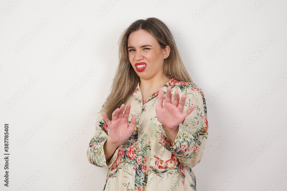 Ugh how disgusting! Displeased young blonde woman standing against white background, says fie and has dissatisfied facial expression as sees something abominable or detestable Ugh how disgusting! Displeased young blonde woman standing against white background, says fie and has dissatisfied facial expression as sees something abominable or detestable