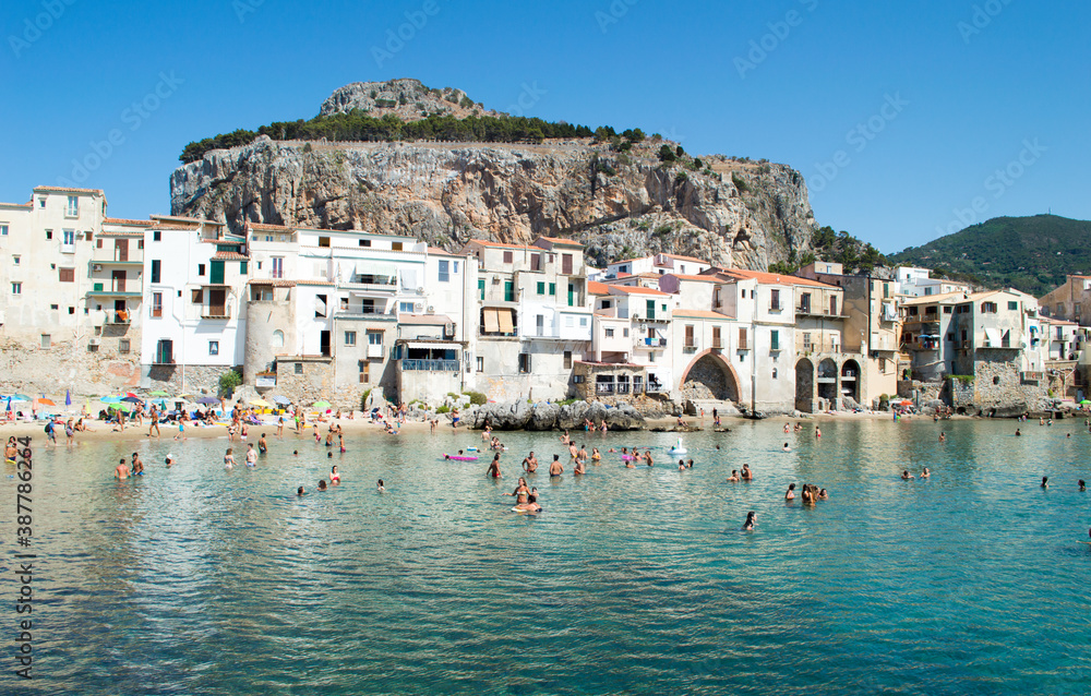 Characteristic view of the coastal city of Cefalù near Palermo in Sicily. It has a cristal clear blue water and nice old houses in front of the sea 