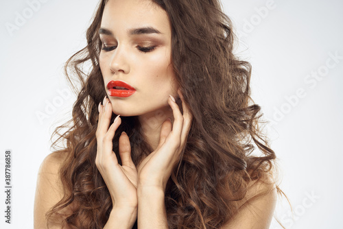 woman with bare shoulders wavy hairstyle glamor makeup light background