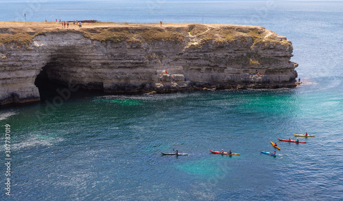 
Kayaks sail on the sea. Kayaks swim up to the sea cave.