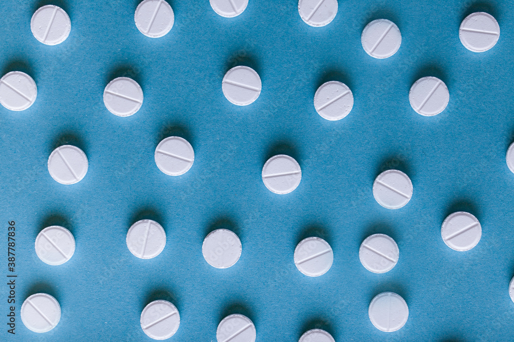 White pills on blue background. 