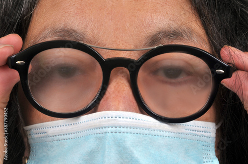 Femme portant un masque avec de la buée sur les lunettes photo