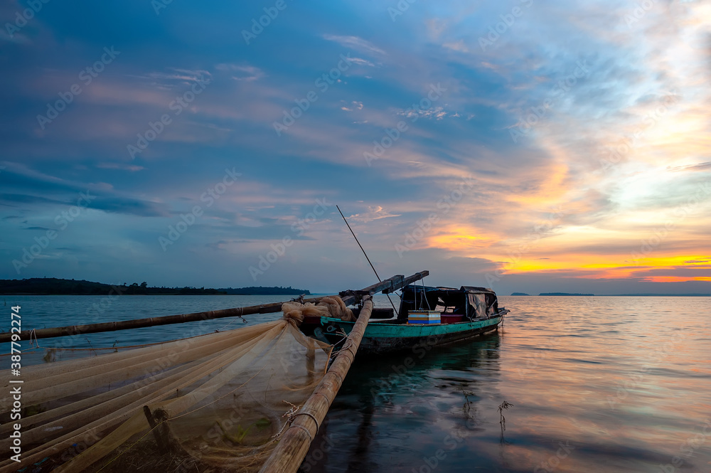 Fishing boat is anchored on Tri An lake in sunset, Dong Nai province, Vietnam.
