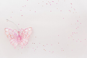 Greeting birthday card with copy space for text or celebration of holidays. Girly composition of glitter and pink butterfly toy, sparkling and elegant feminine scene. Festivity or invitation