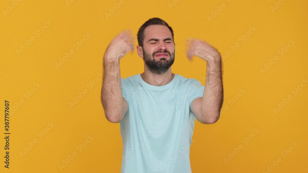 Bearded mad upset young man 20s in basic casual blue t-shirt isolated on yellow background studio. People sincere emotions lifestyle concept. Looking camera crying waving hands ask why sadness problem Bearded mad upset young man 20s in basic casual blue t-shirt isolated on yellow background studio. People sincere emotions lifestyle concept. Looking camera crying waving hands ask why sadness problem