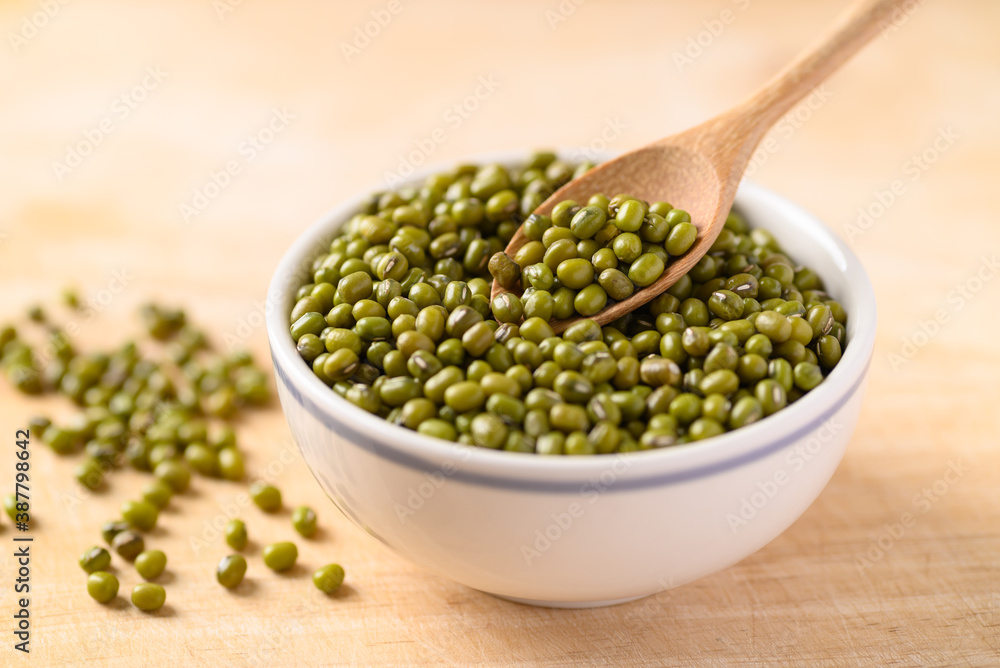 Mung bean with spoon in a bowl on wooden background