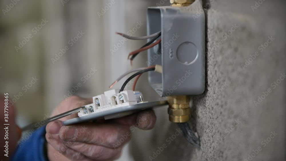 Male hands Wiring A fuse socket in garage, linking light to garage mains. metal framed socket