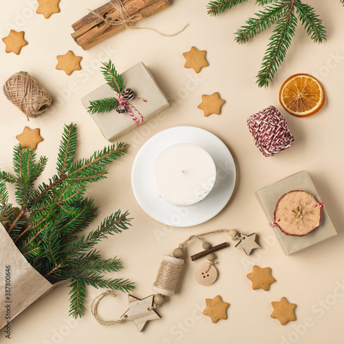 Festive Xmas decorations, homemade gingerbread cookies, fir branches on natural beige background.