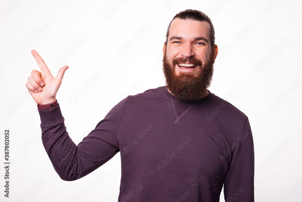 A man is smiling at the camera and is pointing away at a free space . A man is smiling at the camera and is pointing away at a free space .