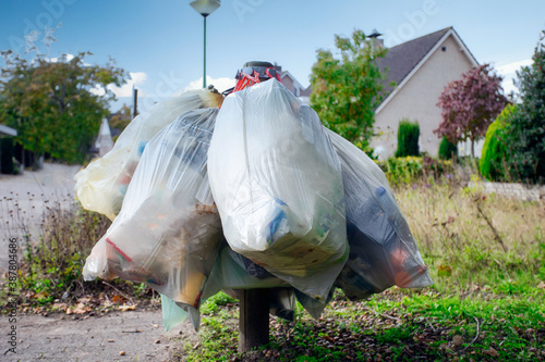 garbage bag for plastic hanging in the street for pick up garbage collector, waiting to destroy. Recycle and environment concept