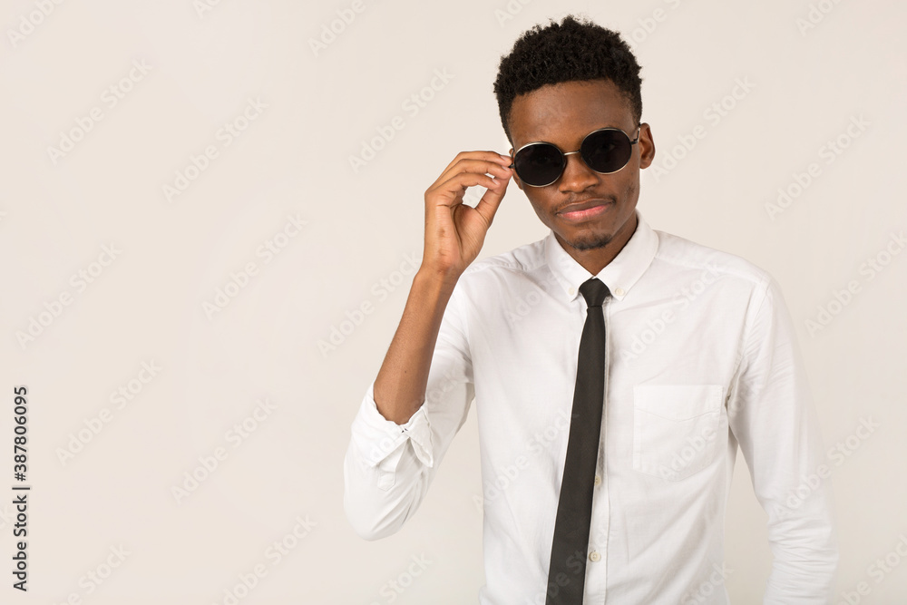 handsome young african male in white shirt wearing black sunglasses handsome young african male in white shirt wearing black sunglasses