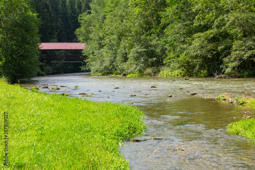 Flusslandschaft der Wertach mit einer überdachten Holzbrücke photo