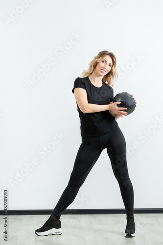 girl in sportswear is engaged in home fitness with a ball. online sports.