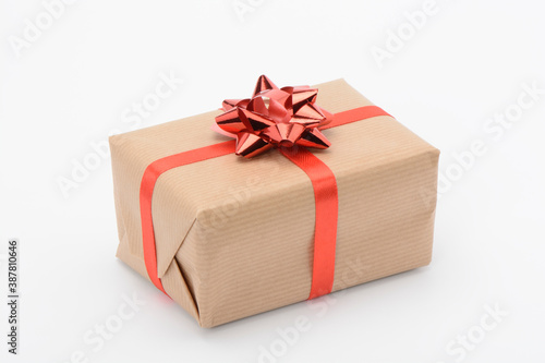 Caja de regalo envuelta con papel marrón y con cinta roja