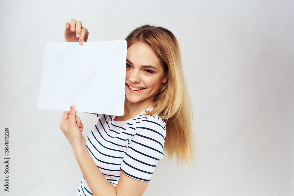 woman holding a sheet of paper in her hands lifestyle striped t-shirt cropped view Copy Space woman holding a sheet of paper in her hands lifestyle striped t-shirt cropped view Copy Space