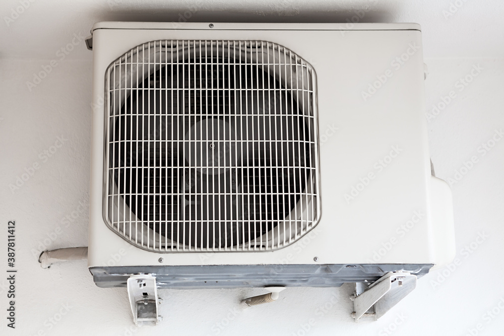 External part of split system air conditioning unit mounted on wall, close up view External part of split system air conditioning unit mounted on wall, close up view