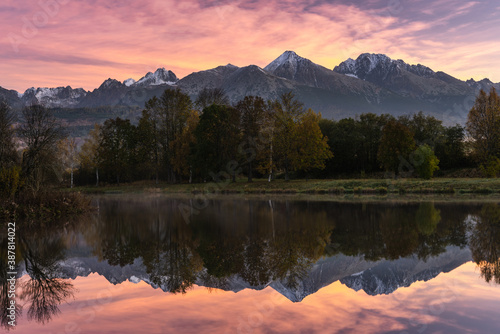 Sunrise at High tatra Mountains. Colorful Sky reflection in Lake. Fall Foliage Colors