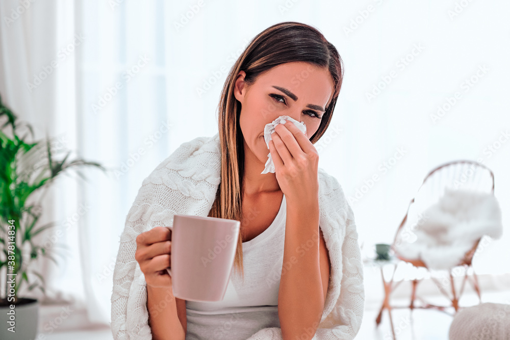Sick woman with headache sitting under the blanket. Sick woman with seasonal infections, flu, allergy sitting on the bed. Sick woman with headache sitting under the blanket. Sick woman with seasonal infections, flu, allergy sitting on the bed.