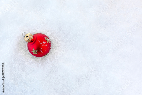 Christmas Card with Red Ball in a snow. Christmas and New Year concept. Top view. Copy space.