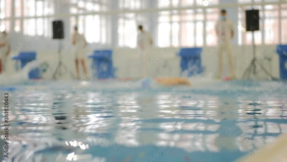 several teen swimmers start at the same time in the pool. They swim the distance brass style several teen swimmers start at the same time in the pool. They swim the distance brass style